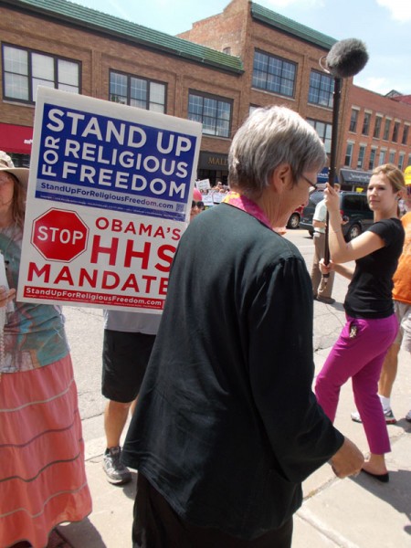 In Janesville, WI, Sister Simone Campbell, Executive Director of NETWORK and head "nun on the bus", ignores Jeanne's signs begging her to help stop the immoral "HHS mandate" of the Affordable Care Act.